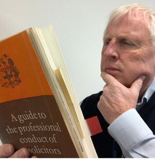 Peter studying the guide to professional conduct