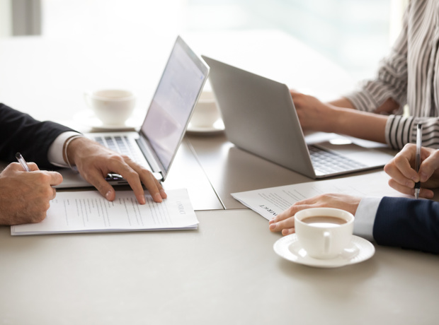 people with computer sat opposite each other across a desk