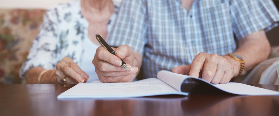 Elderly Couple Signing Document
