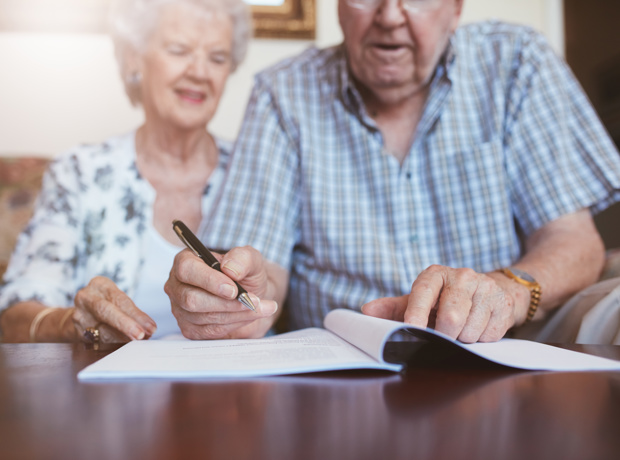 Elderly Couple Signing Document