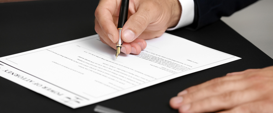 person signing document with fountain pen