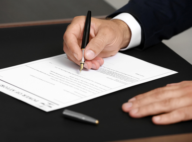 person signing document with fountain pen