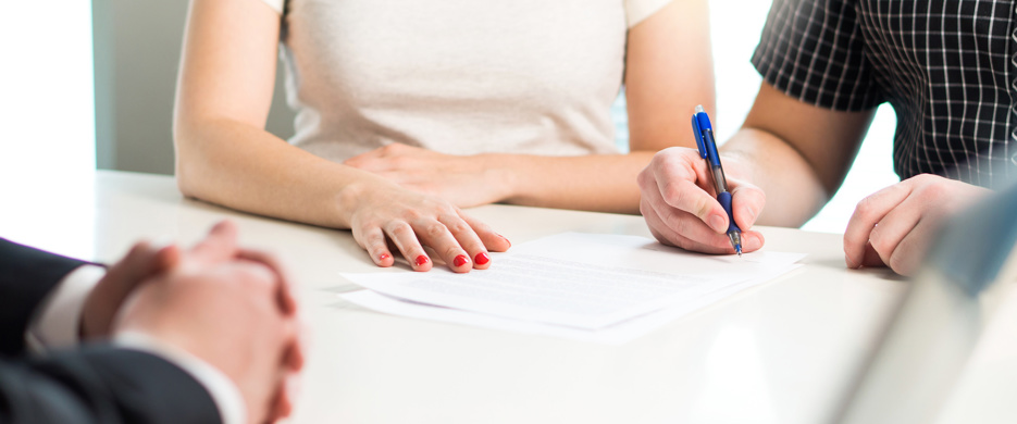 Two People Signing Document