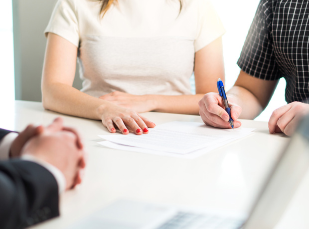 Two People Signing Document