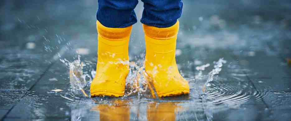 Child In Wellies Splashing In Puddles