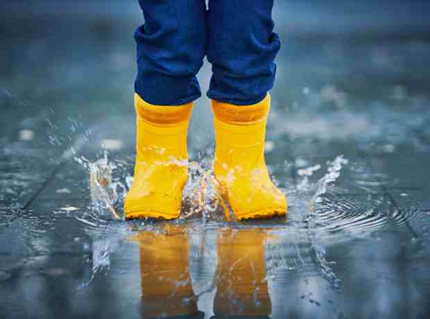 Child In Wellies Splashing In Puddles