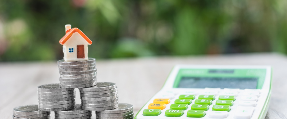 house on coins next to a calculator
