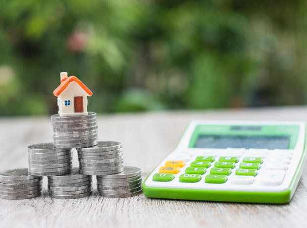 house on coins next to a calculator