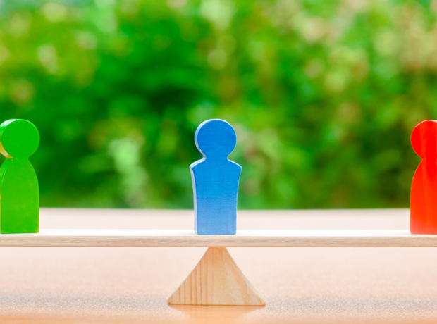 wooden seesaw with one figure at each end and one in the middle