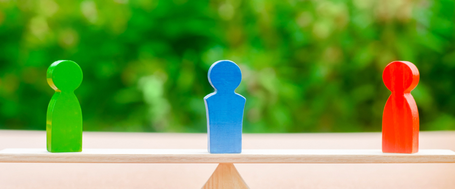 wooden seesaw with one figure at each end and one in the middle